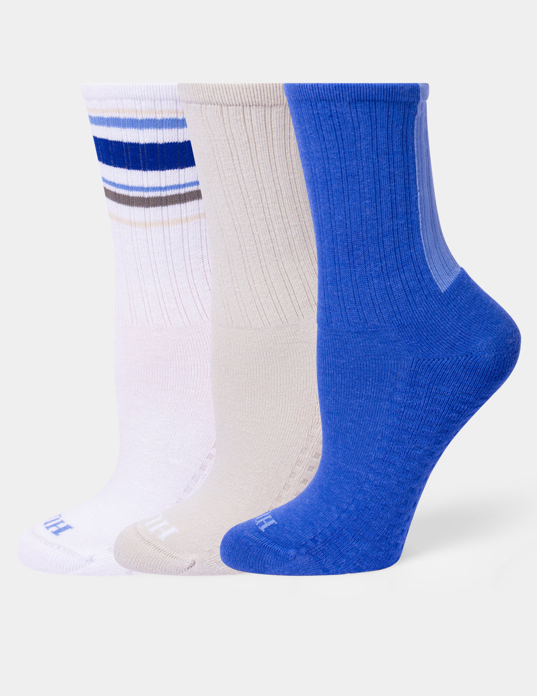 Three pairs of ribbed crew socks in white, beige, and royal blue, arranged side-by-side on a light gray background.