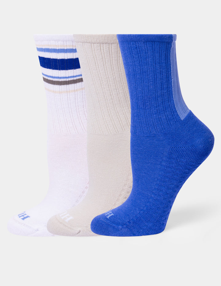 Three pairs of ribbed crew socks in white, beige, and royal blue, arranged side-by-side on a light gray background.