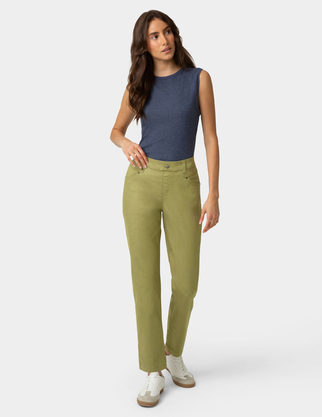 Woman wearing green pants and a blue top on a white background