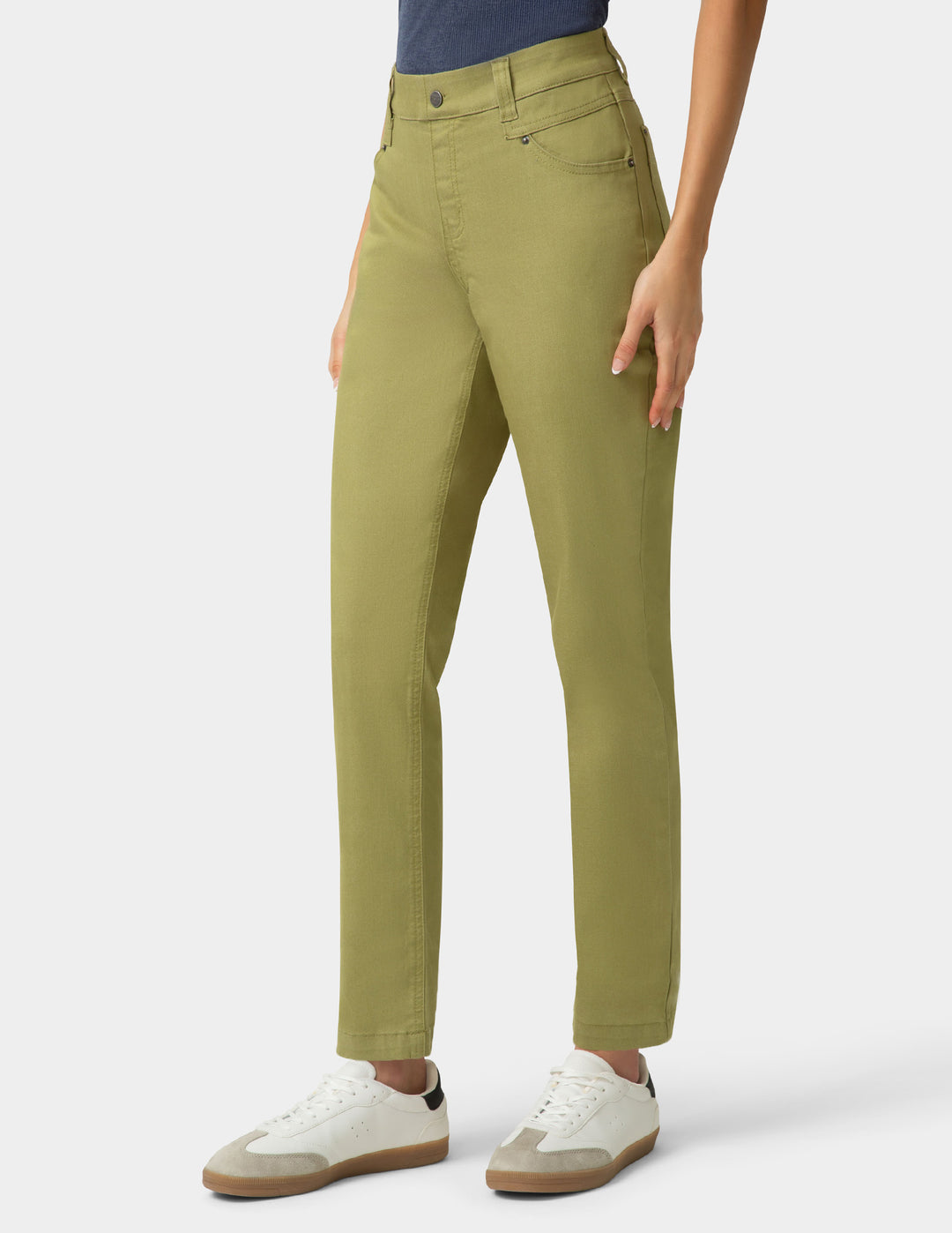 Person wearing green pants and white sneakers on a white background