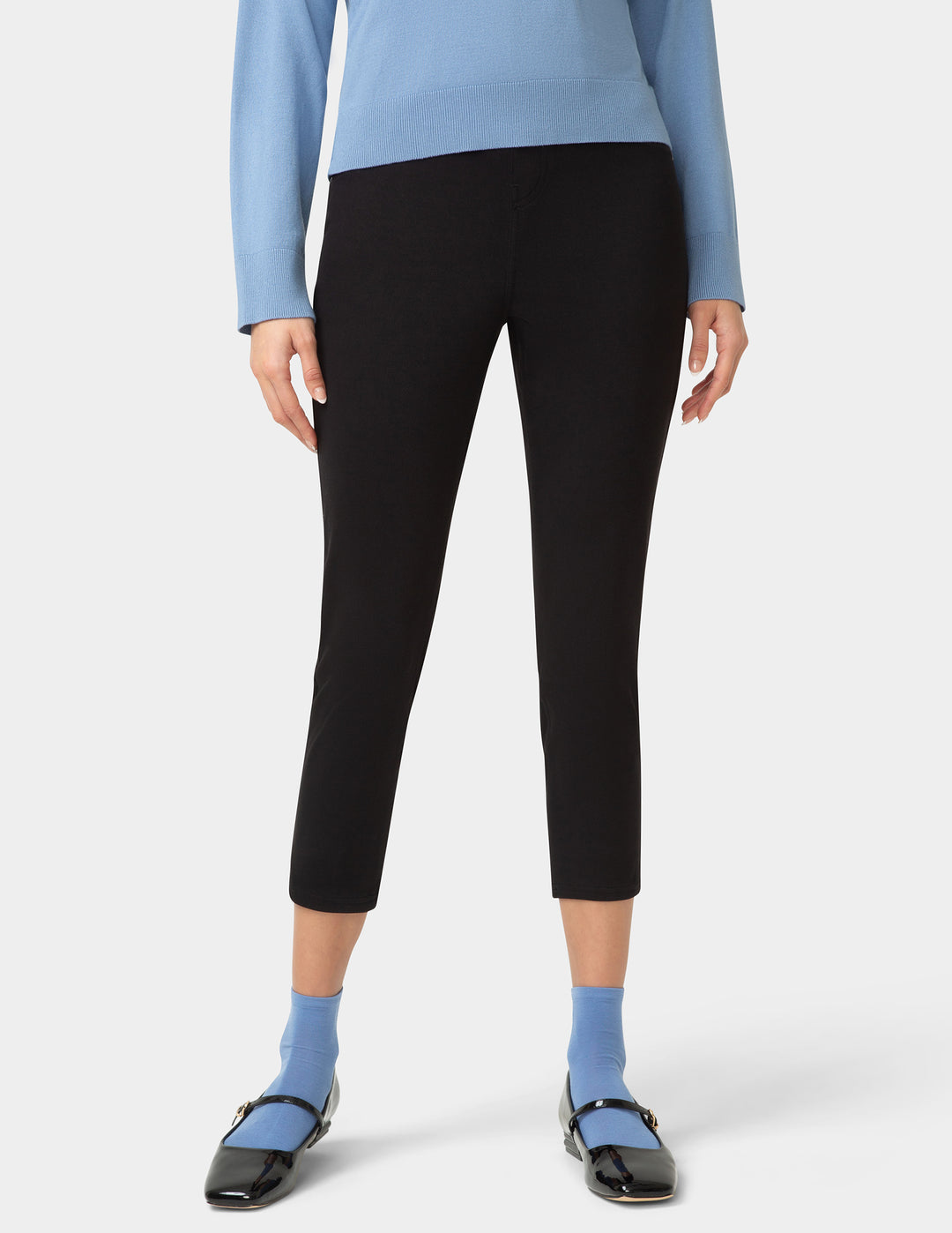 Person wearing blue pair of socks with shoes, a blue shirt, and black pants