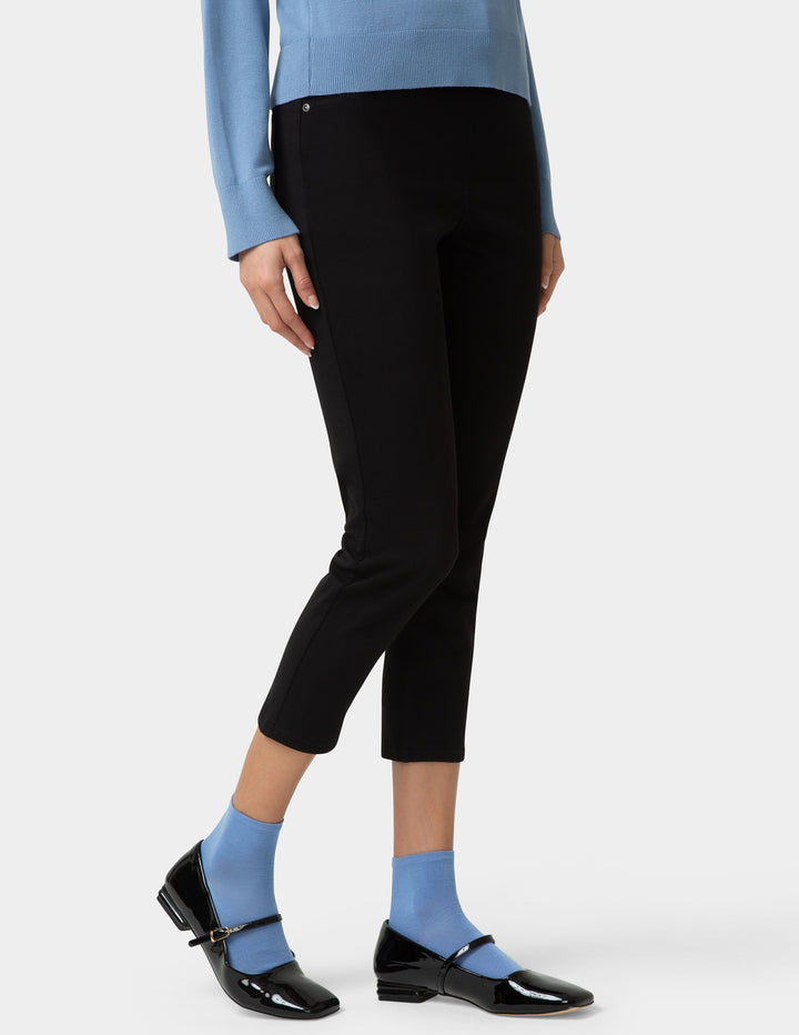 Person wearing blue pair of socks with shoes, a blue shirt, and black pants