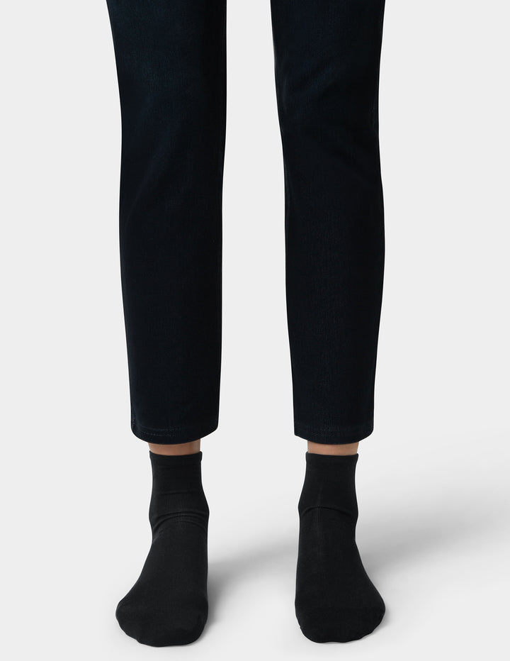 Person wearing black pants and socks on a white background