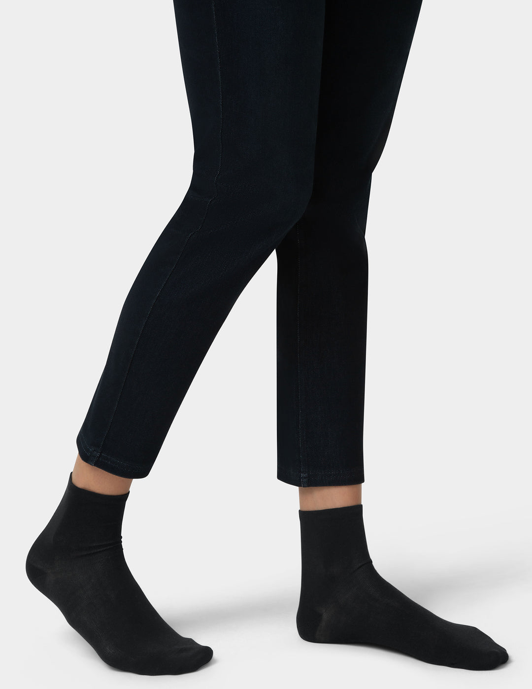 Person wearing black pants and socks on a white background