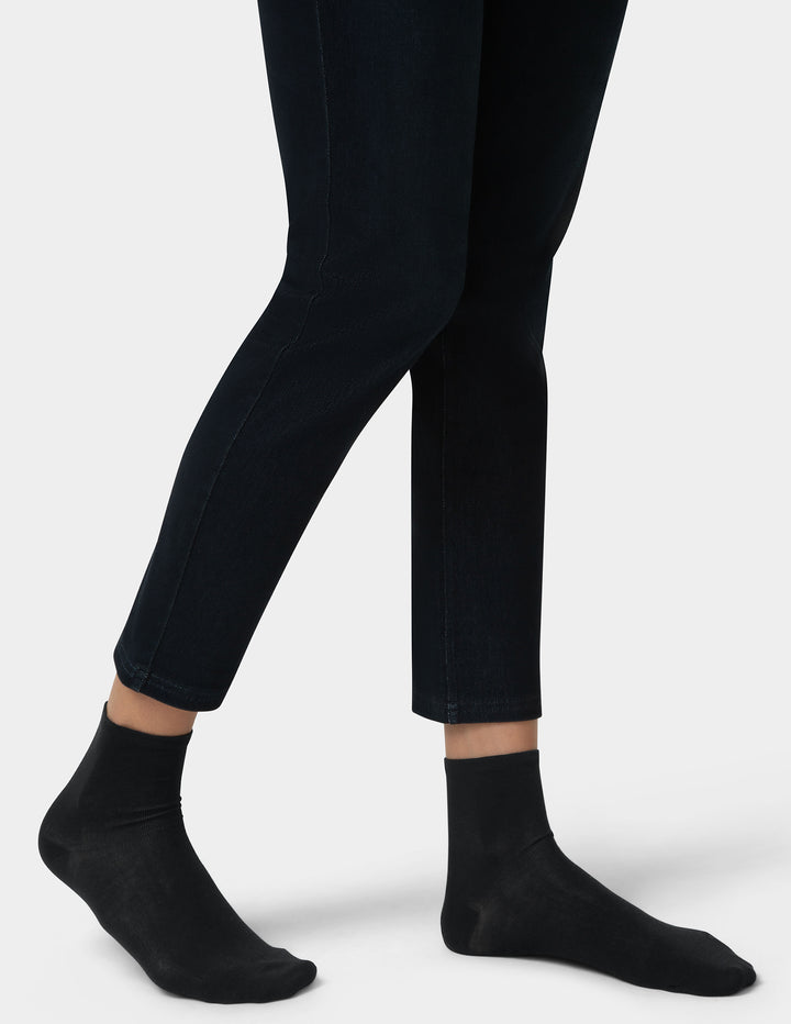 Person wearing black pants and socks on a white background