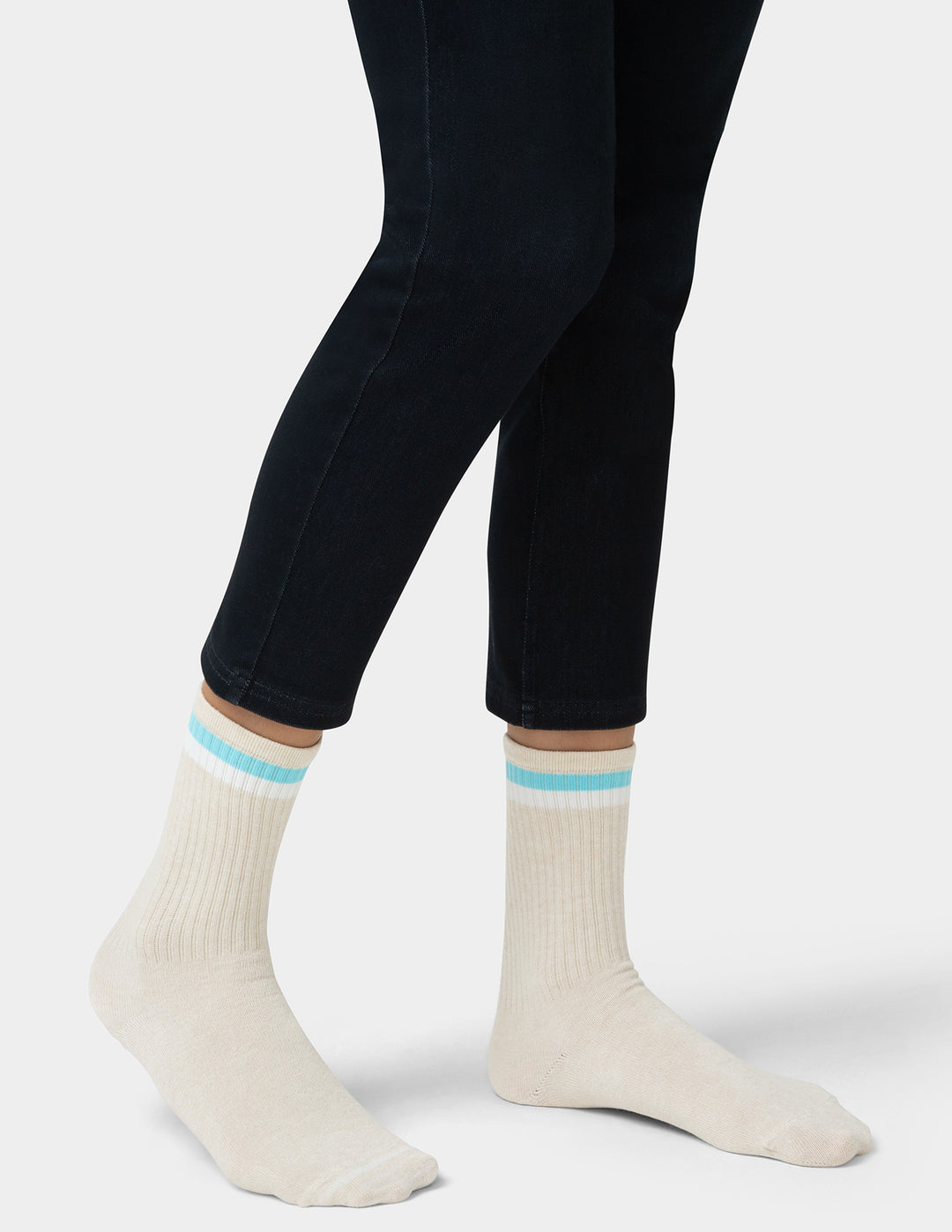 White socks with blue stripes worn with black pants on a white background