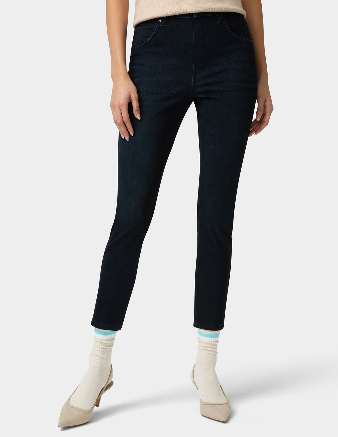 Person wearing dark blue jeans with a white background