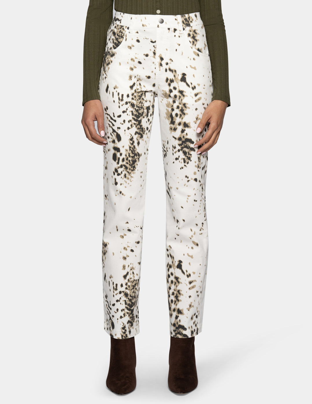 A woman modeling white straight leg pants with a brown animal print pattern throughout.
