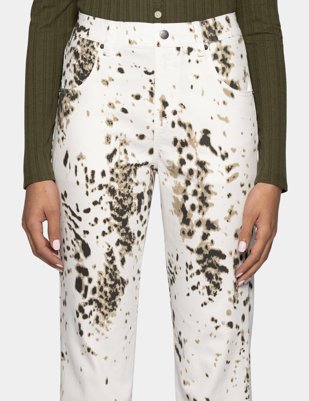 Closeup view of a woman modeling white straight leg pants with a brown animal print pattern throughout.