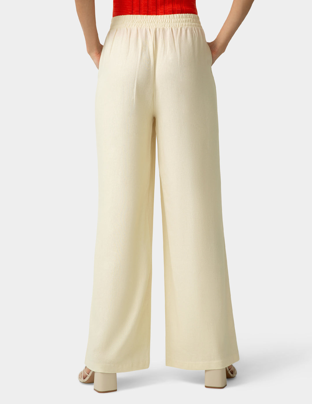 Beige wide-leg pants worn by a person on a white background