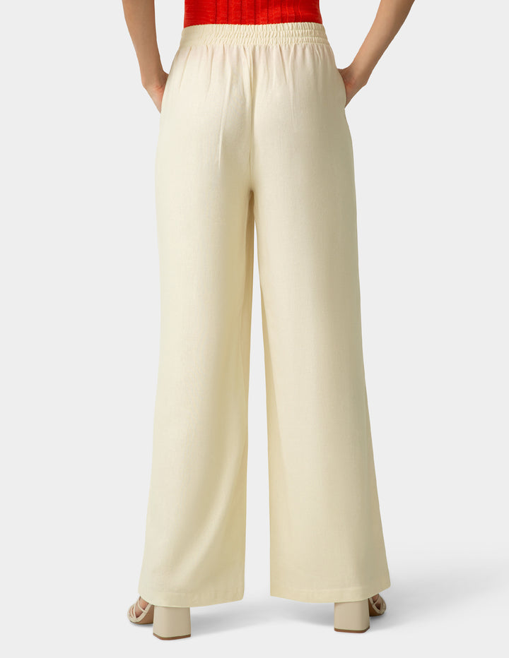Beige wide-leg pants worn by a person on a white background