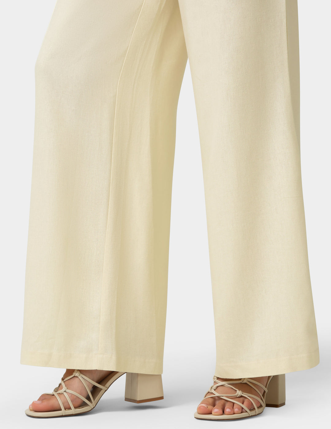 Beige pants worn by a person on a white background
