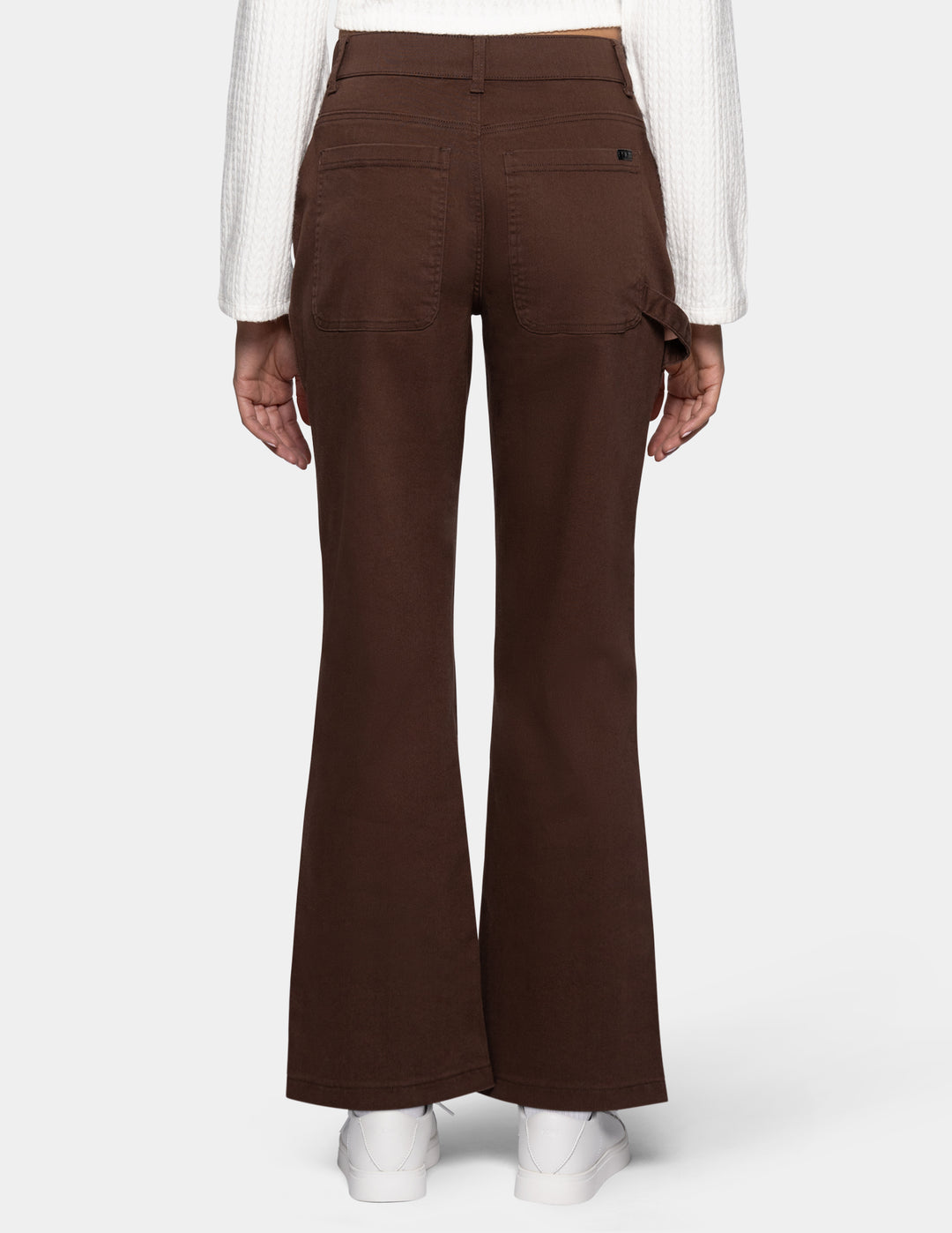 A person shown from the back wearing dark brown flared pants 