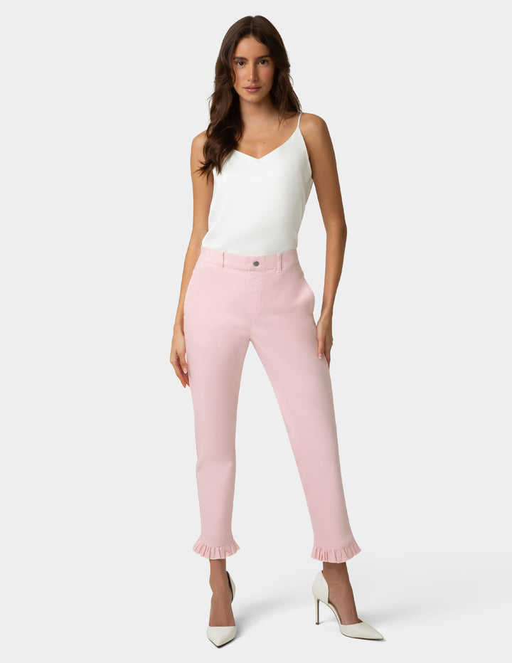 Woman wearing a white top and pink pants on a white background
