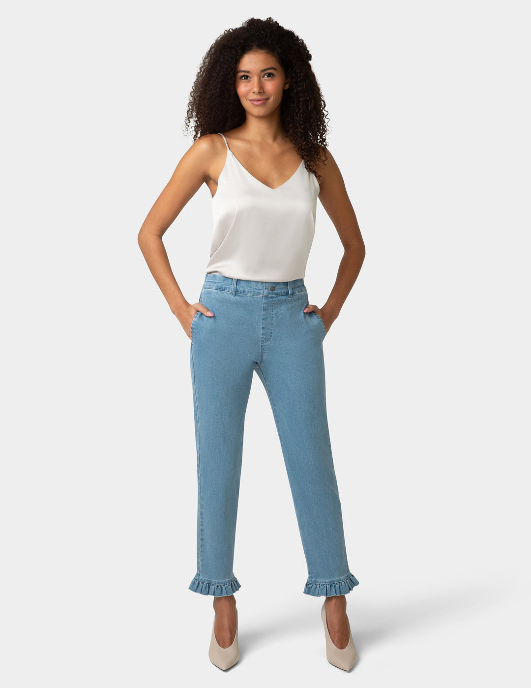 Woman wearing a white top and light blue jeans on a white background