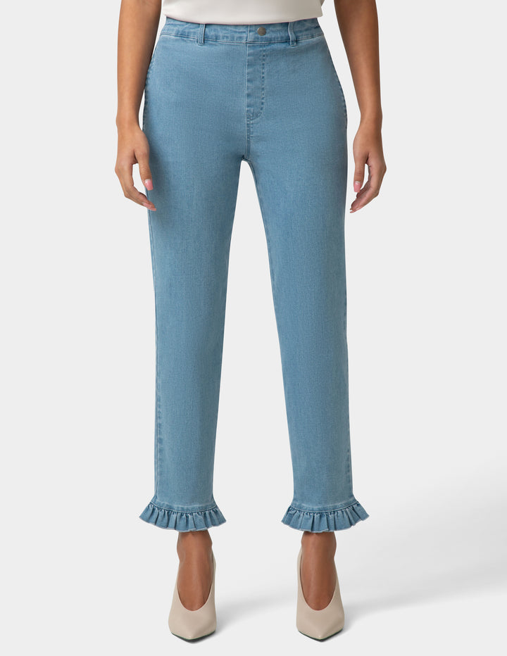Light blue jeans with ruffled cuffs worn by a person on a white background