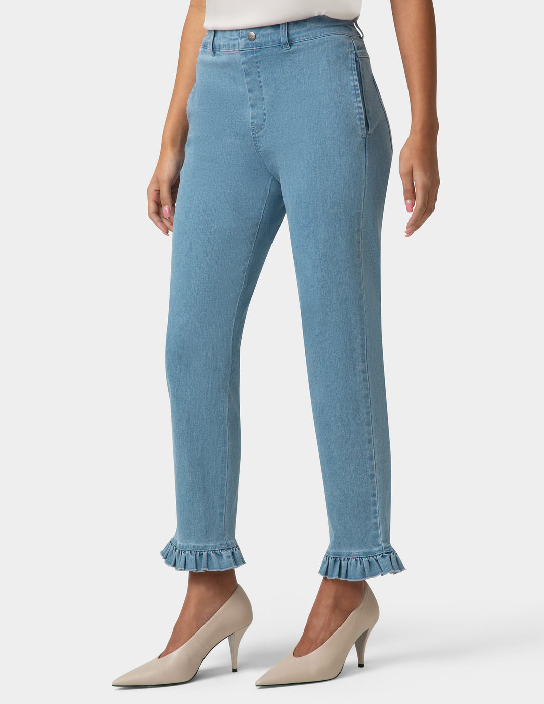 Light blue jeans with ruffled cuffs worn by a person on a white background