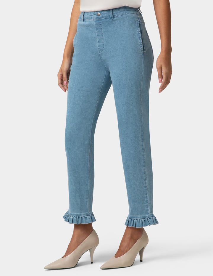 Light blue jeans with ruffled cuffs worn by a person on a white background
