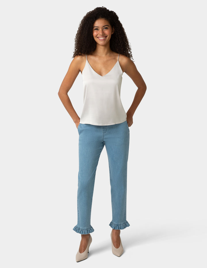 Woman wearing a white top and light blue jeans on a white background