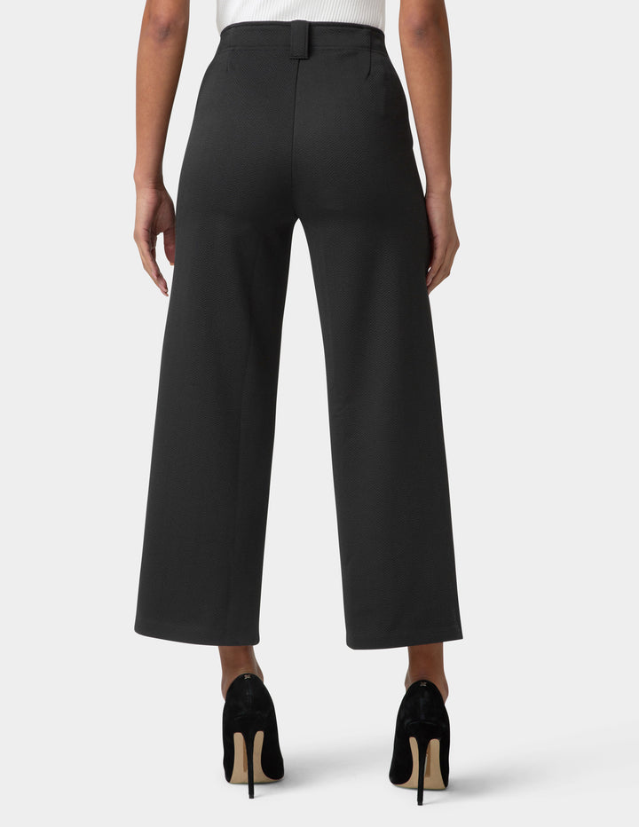 Black wide-leg pants worn by a person on a white background