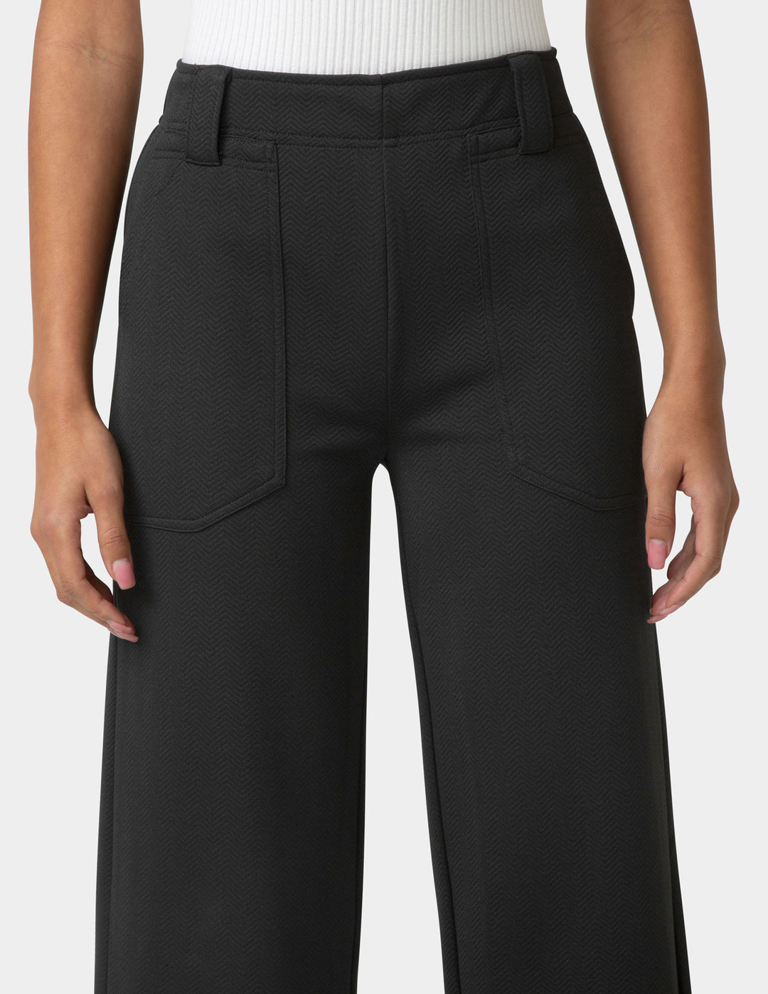 Black pants worn by a person on a white background