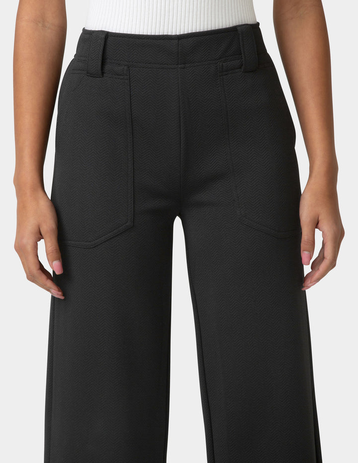 Black pants worn by a person on a white background
