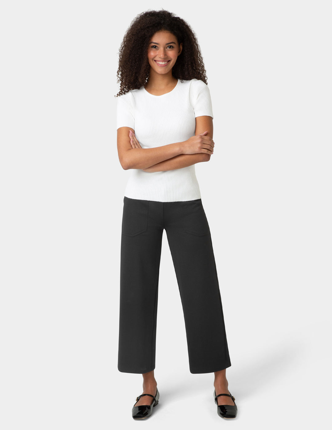 Woman wearing a white t-shirt and black pants on a white background