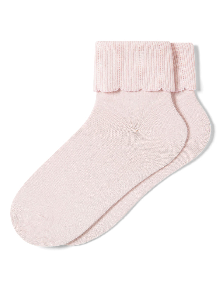 Pink sock with ruffled top on a white background