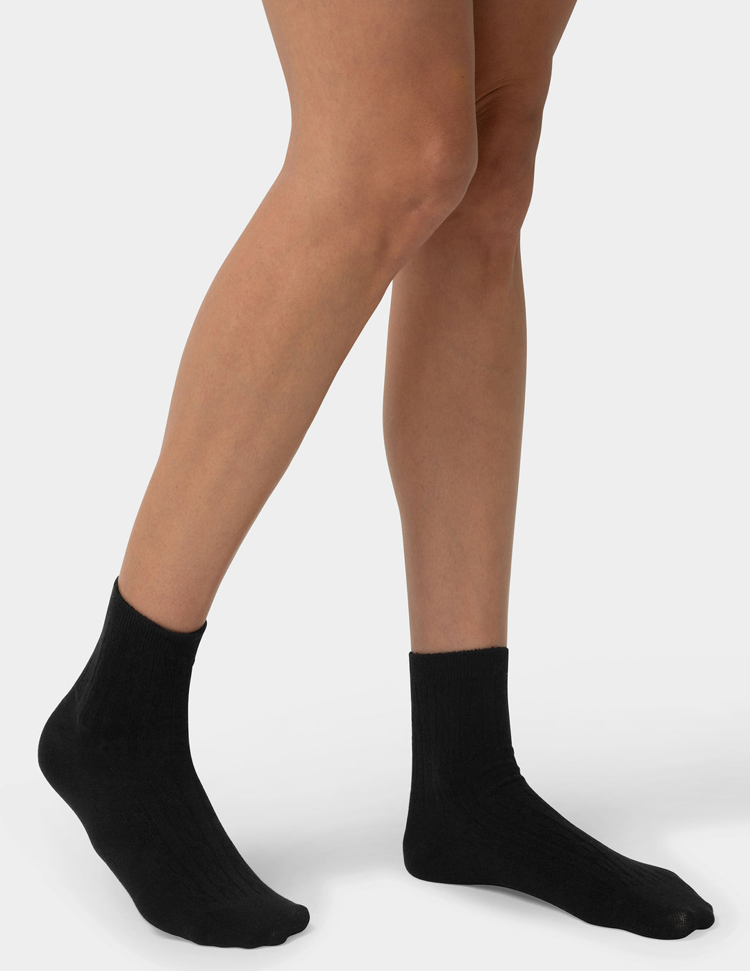 Person wearing black socks on a plain background