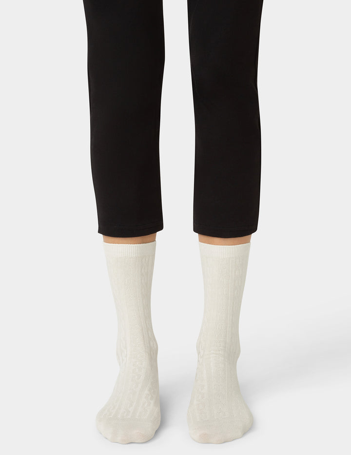 White socks worn with black pants on a white background