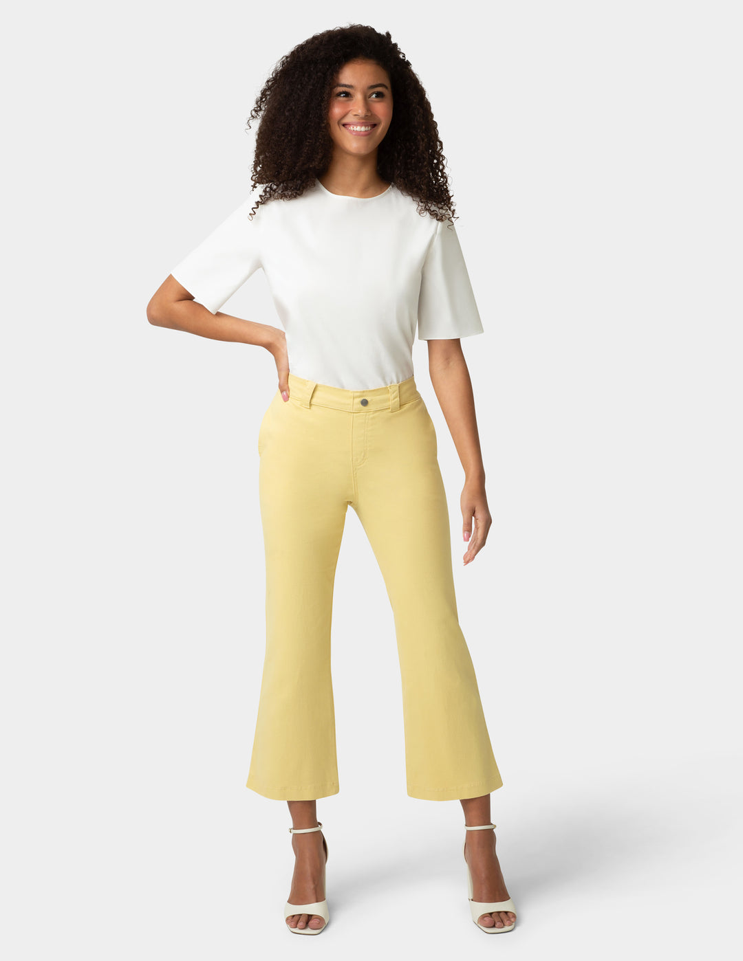 Woman wearing a white top and yellow pants on a white background