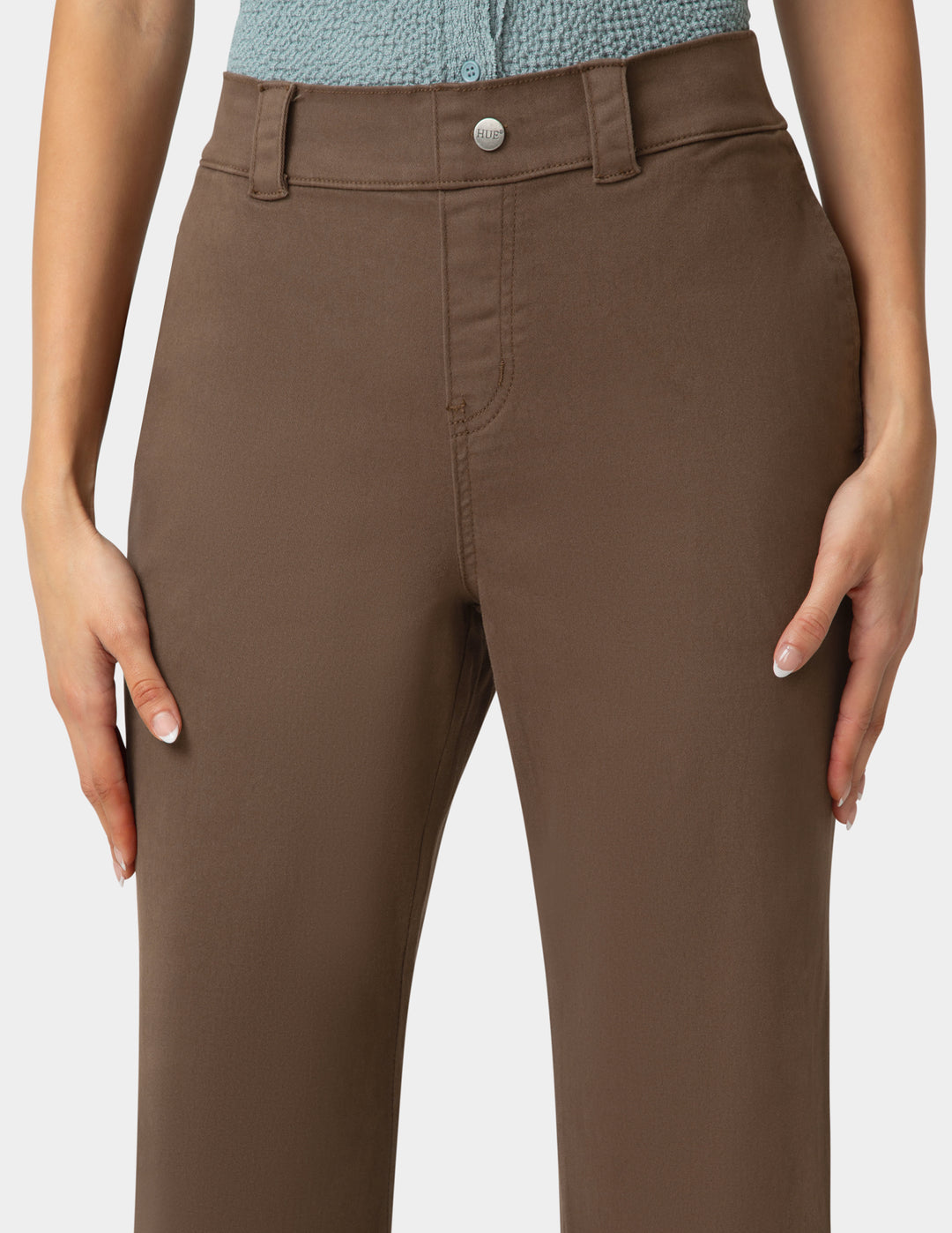 Brown pants worn by a person on a plain background