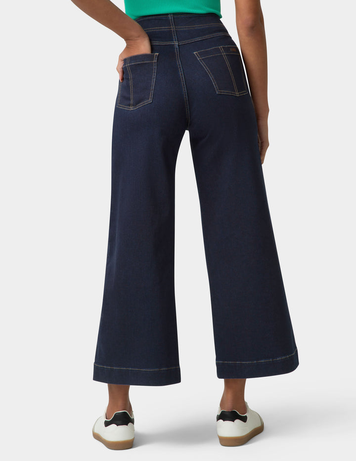 Navy wide-leg jeans worn by a person on a white background