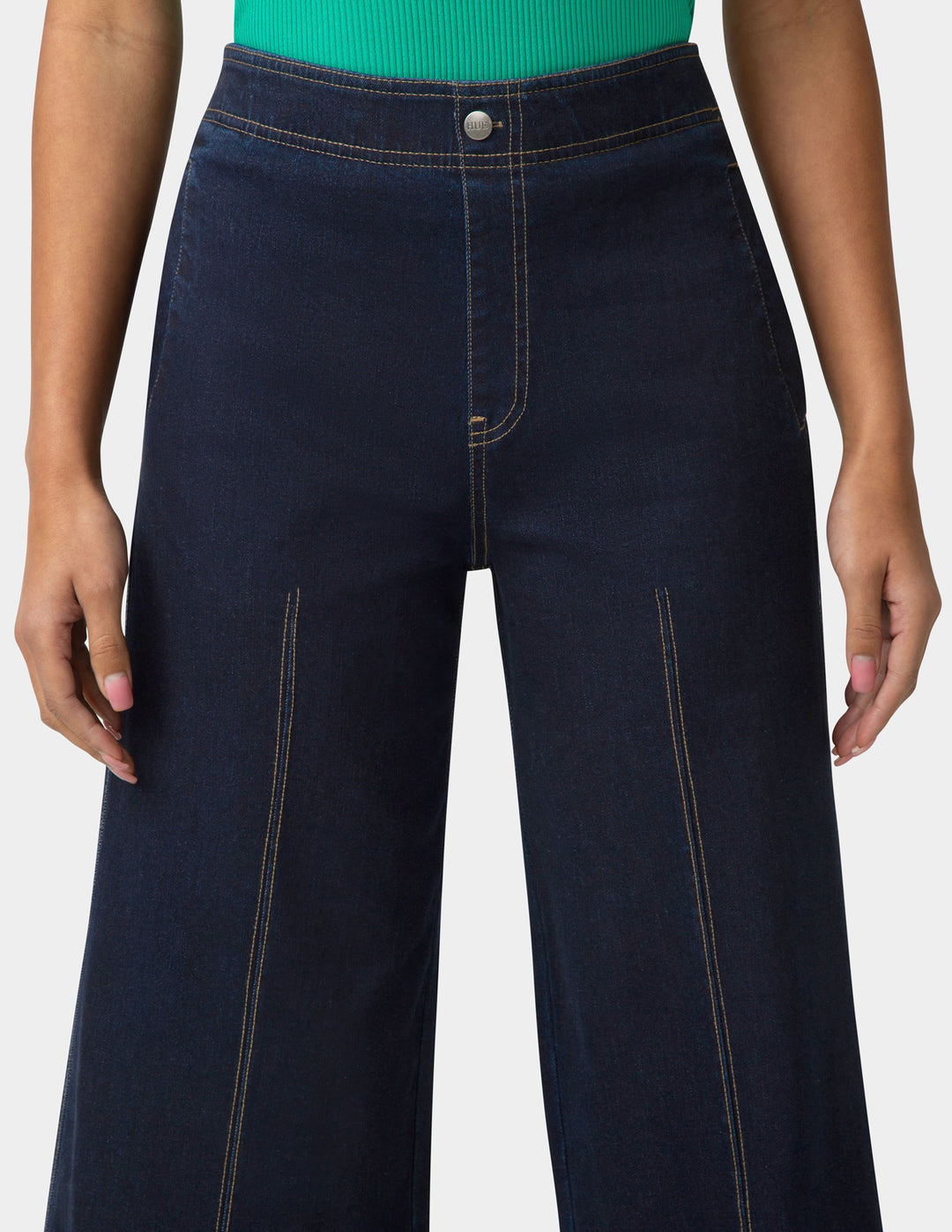 Navy blue jeans worn by a person on a white background