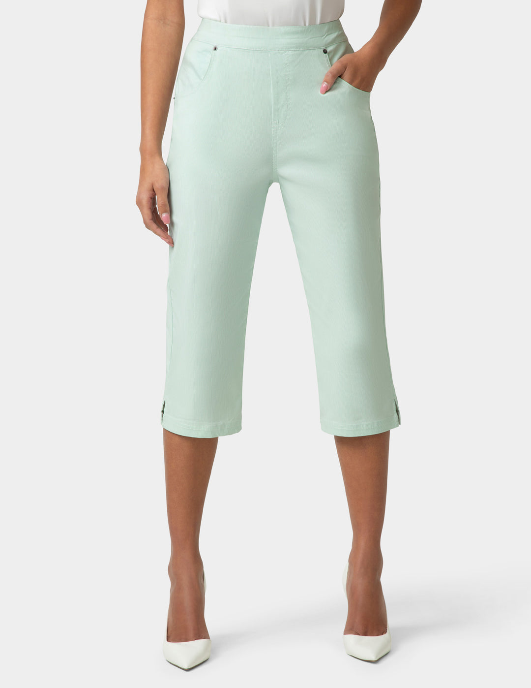 Person wearing light green capri pants on a white background