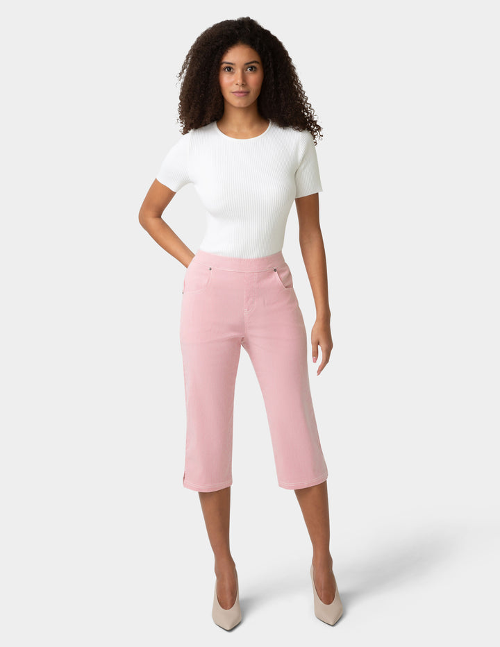 Woman wearing a white top and pink pants on a white background