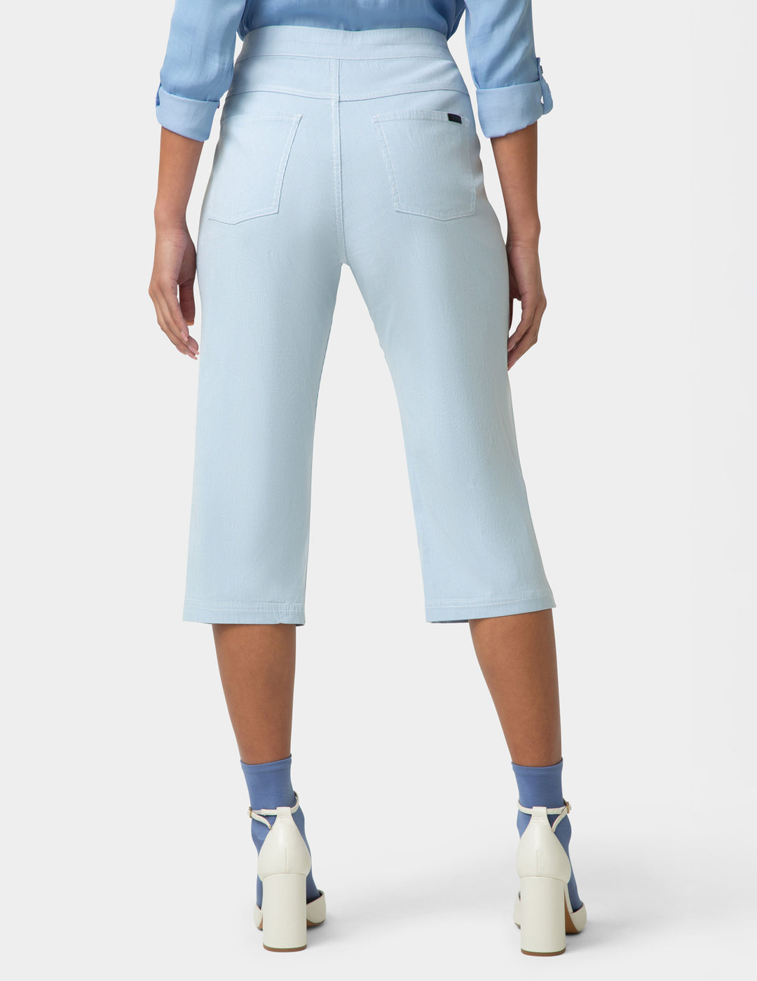 Light blue capri pants worn by a person on a white background