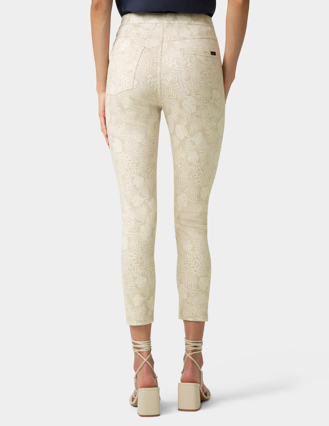 Beige pants worn by a person on a white background