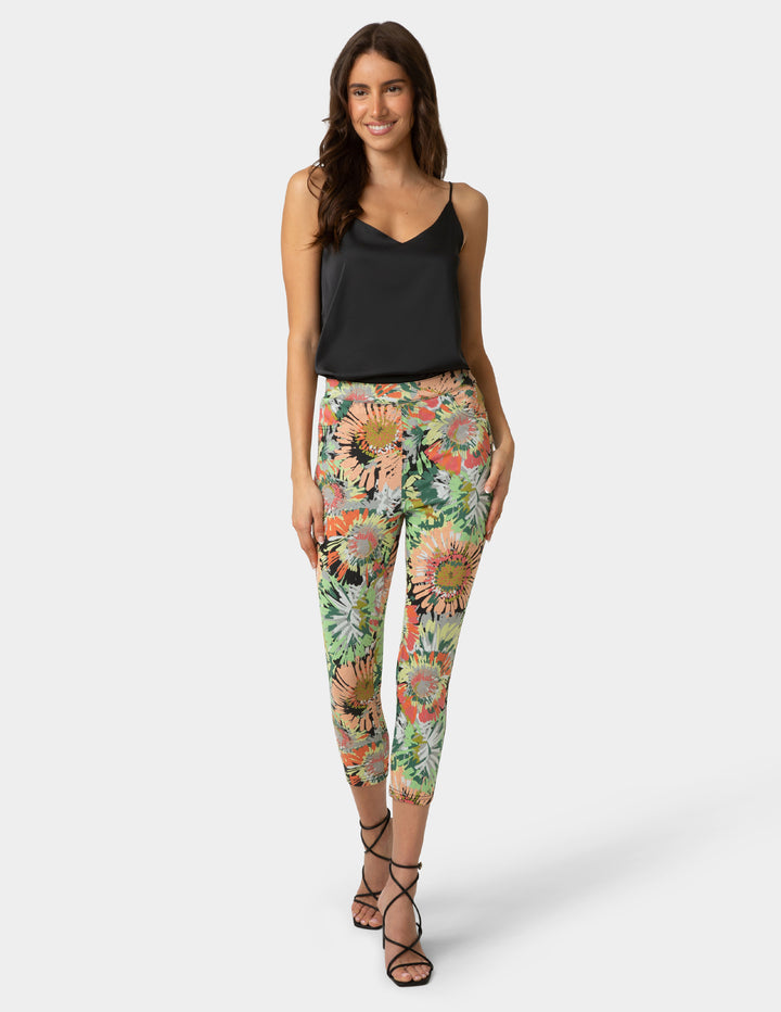 Woman wearing floral pants and a black top on a white background