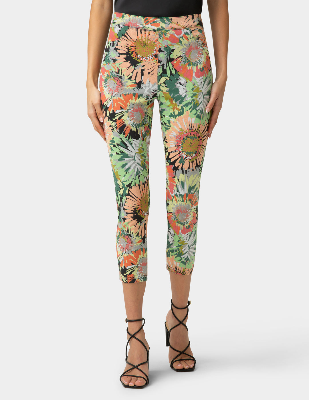Person wearing colorful floral leggings on a white background