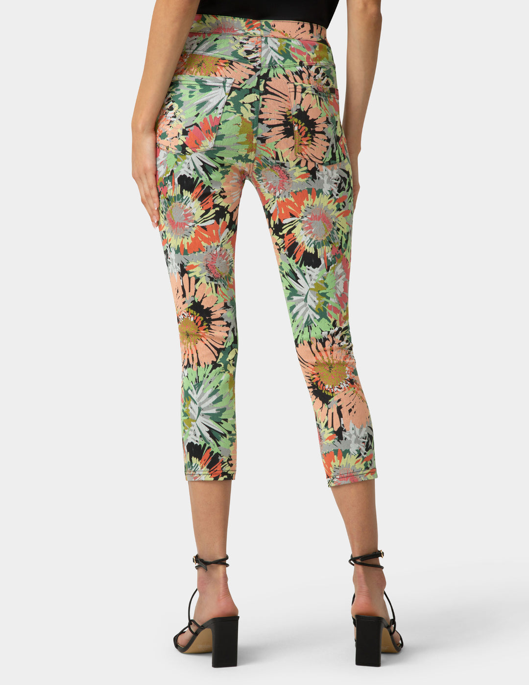 Capri leggings with a tropical floral pattern worn by a person on a white background