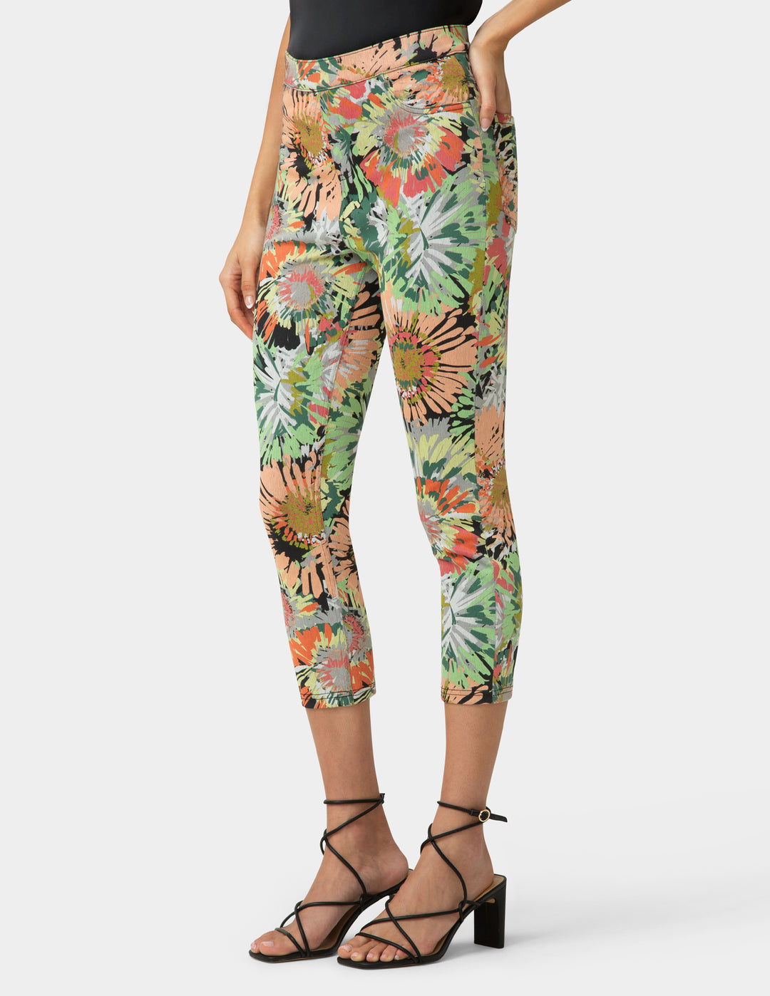 Person wearing colorful floral leggings on a white background