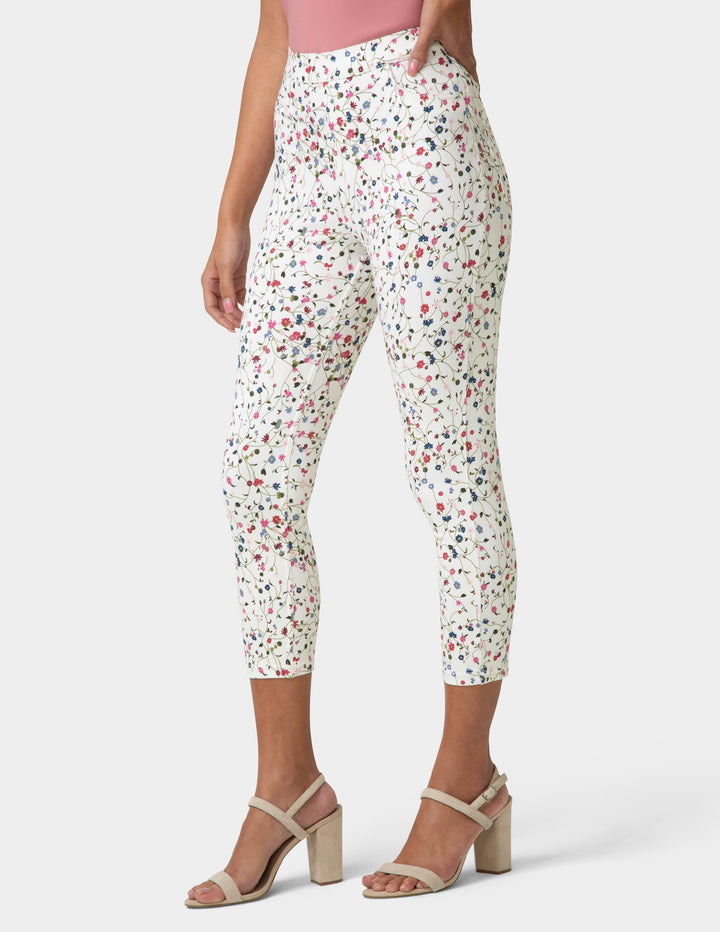 White pants with colorful floral pattern worn by a person on a white background