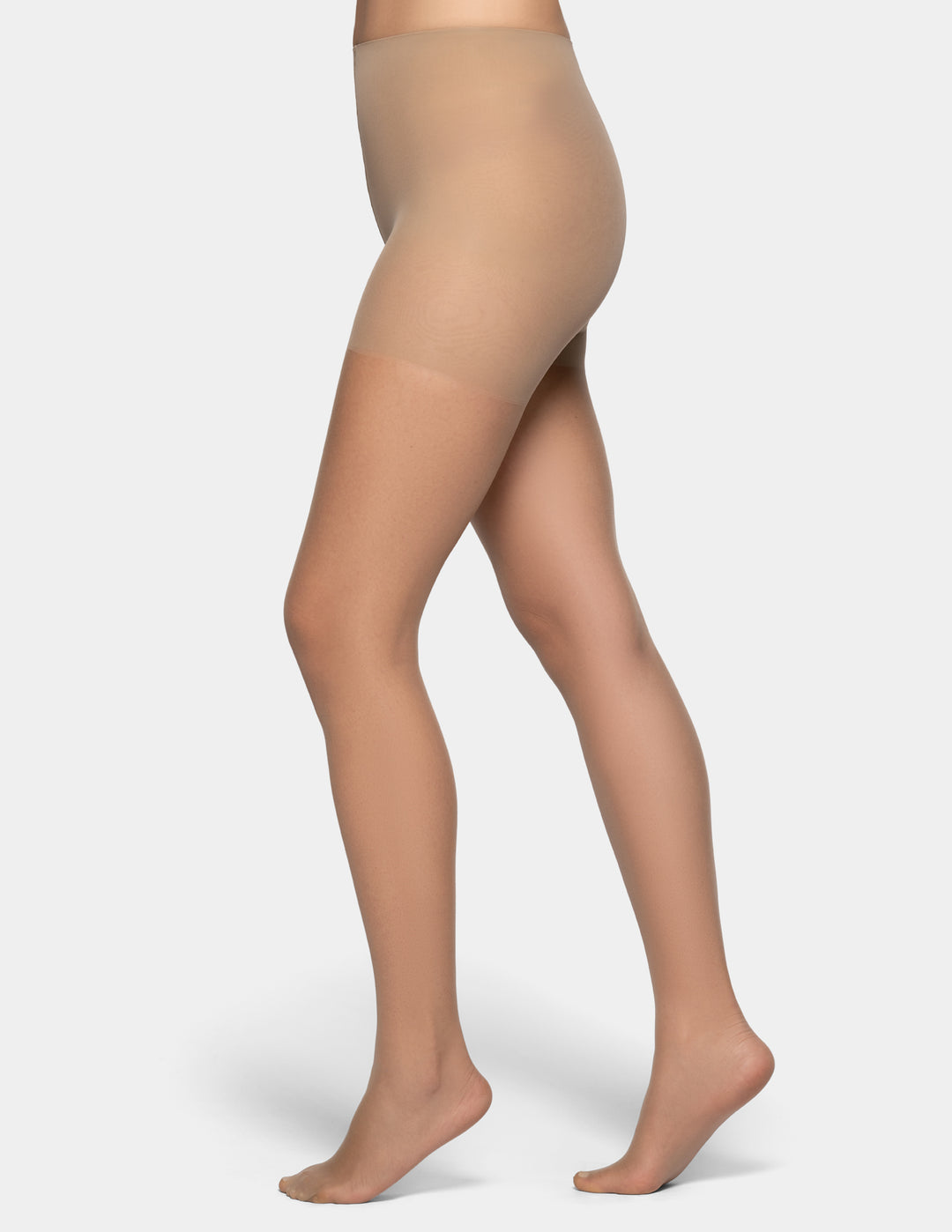 Side view of a model's legs wearing sheer beige hosiery/tights against a plain light gray background.