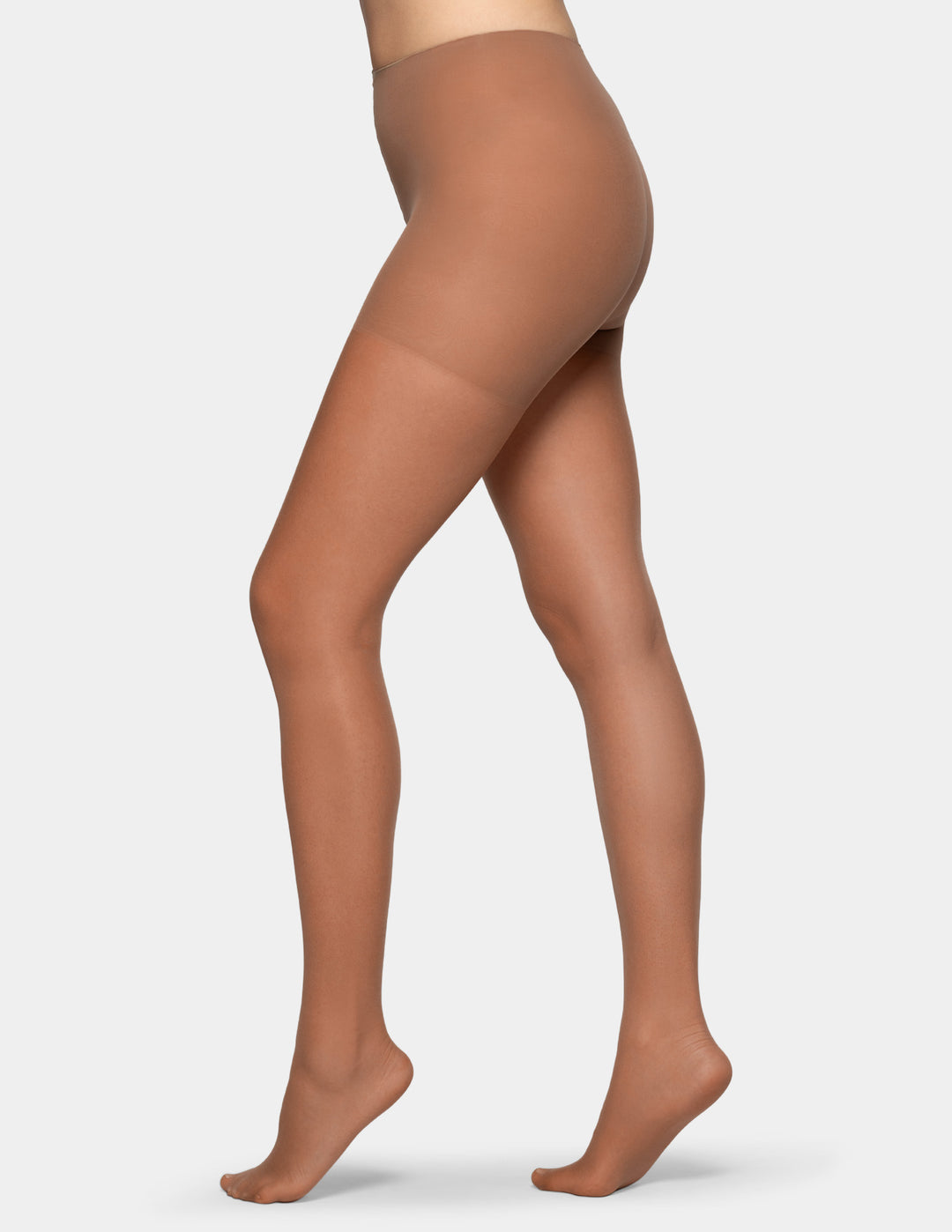 A model's legs wearing sheer, skin-toned hosiery tights, shown from the waist down against a light gray background.