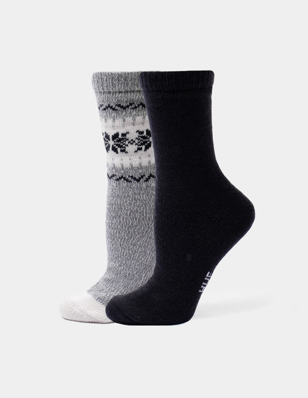 A pair of crew socks shown on invisible forms against a light gray background. One sock is heather gray with a black and white Fair Isle pattern near the cuff and a white toe.