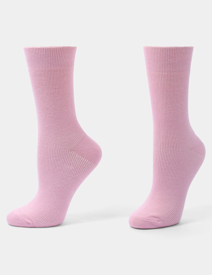 A pair of light pink ribbed crew socks shown from the side against a clean, light gray background.