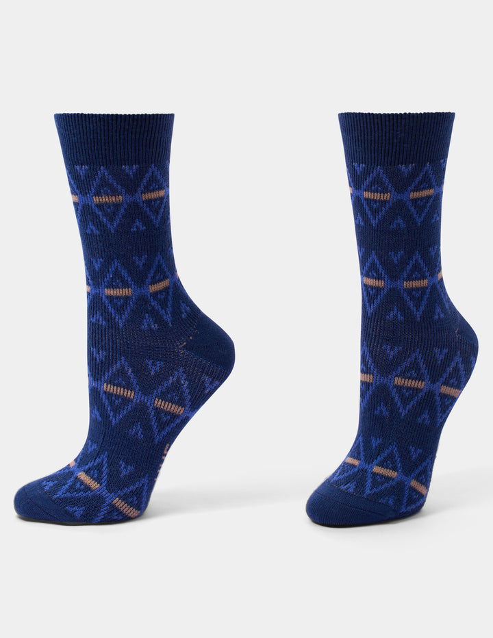 A pair of navy blue crew socks with a geometric pattern in lighter blue and tan, displayed on a light gray background.