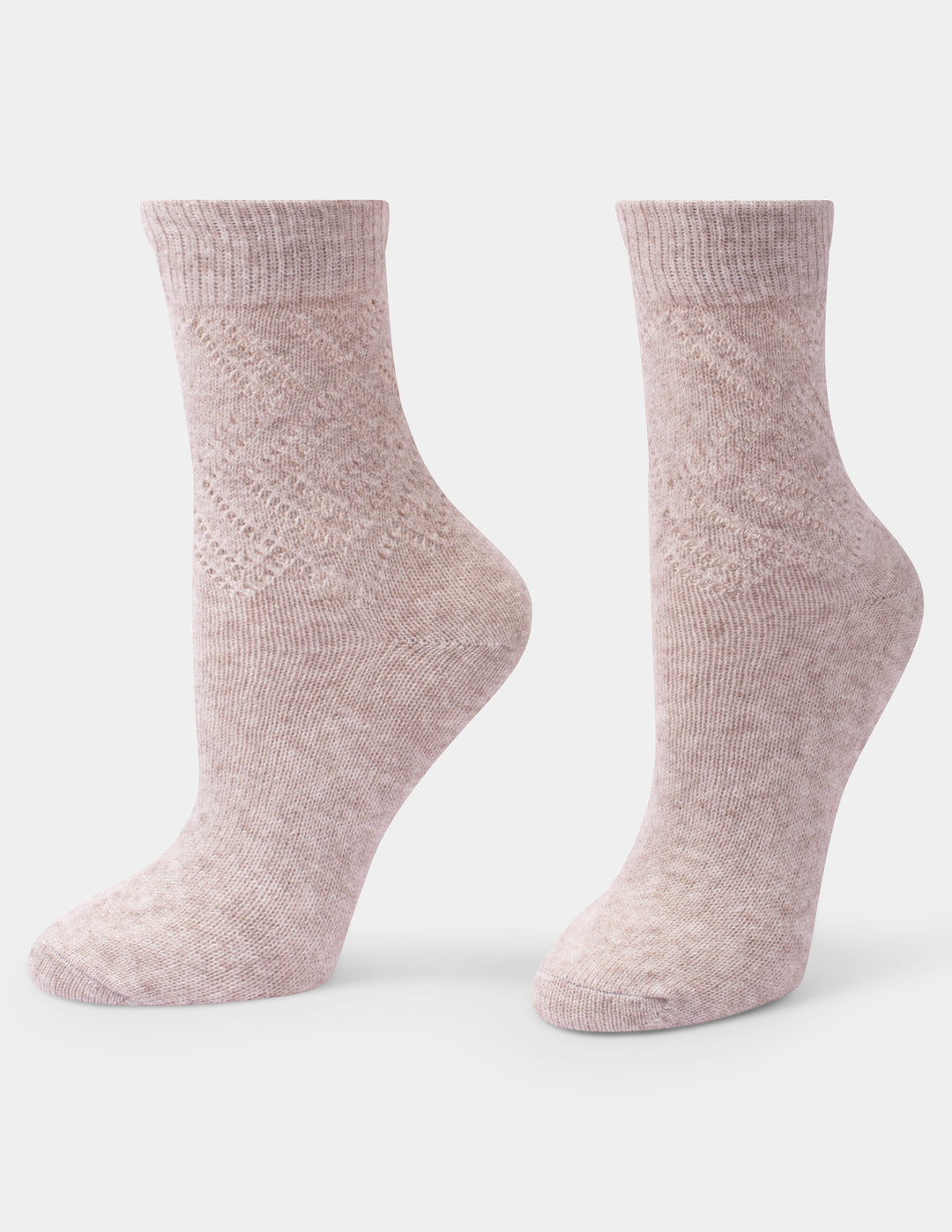 A pair of light beige knit socks with a textured diamond pattern on the upper leg, displayed on invisible forms against a light gray background.