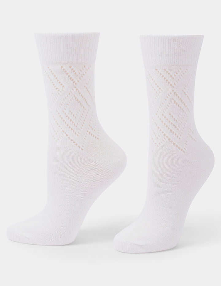 A pair of white crew socks with a textured, openwork diamond pattern on the lower half, displayed on invisible forms against a light gray background.